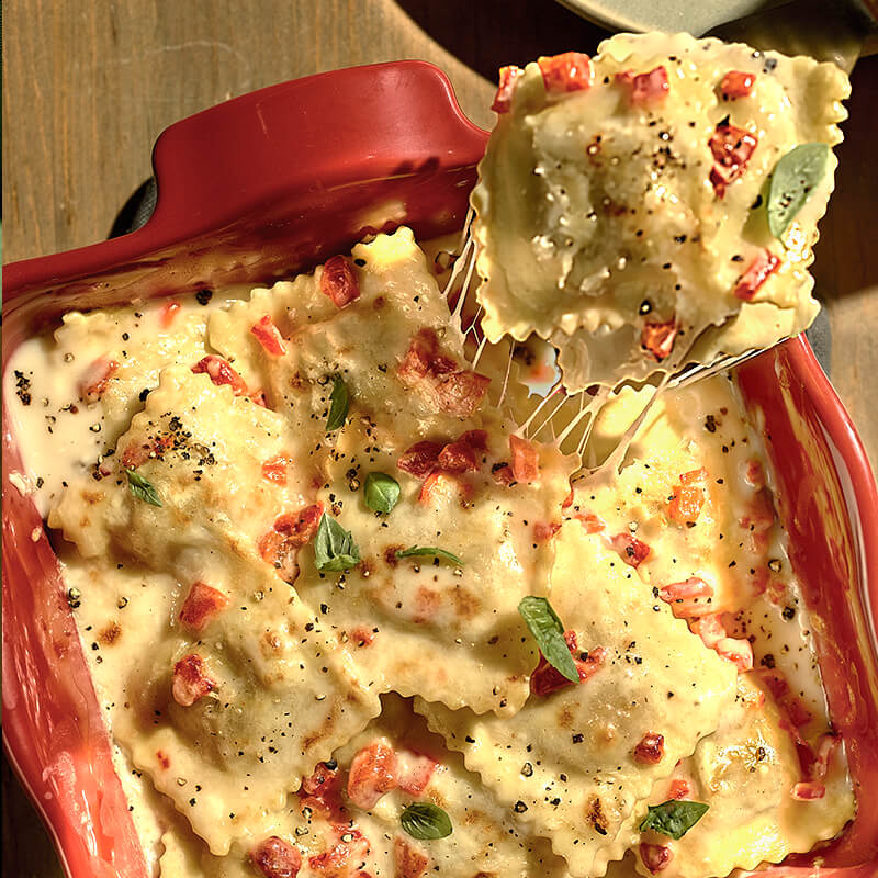 Creamy Ravioli Lasagna Bake with Roasted Red Peppers and Alfredo Sauce featuring Impossible™ Beef Made From Plants